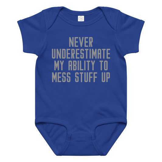 "Never Understimate My Ability To Mess Stuff Up" printed on a royal baby jersey bodysuit laying on a flat surface amongst other clothes