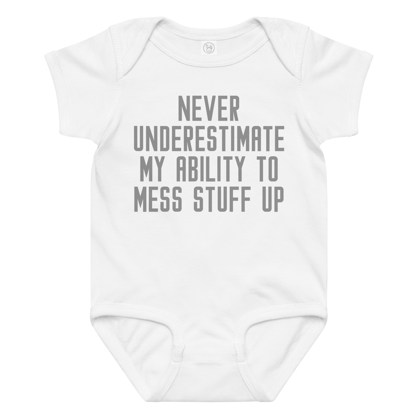 "Never Understimate My Ability To Mess Stuff Up" printed on a white baby jersey bodysuit laying on a flat surface amongst other clothes