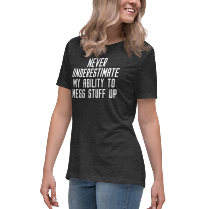 "Never Understimate My Ability To Mess Stuff Up" printed on a dark grey heather women's relaxed t-shirt worn by a female