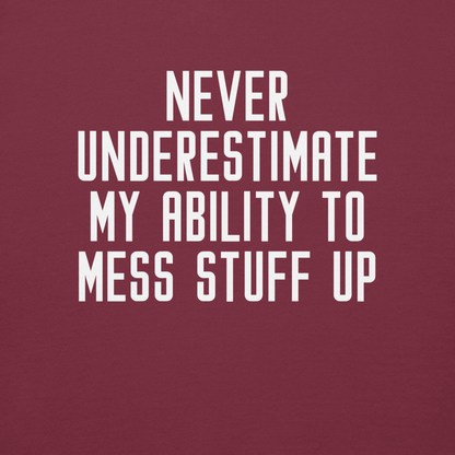 "Never Understimate My Ability To Mess Stuff Up" printed on a maroon background