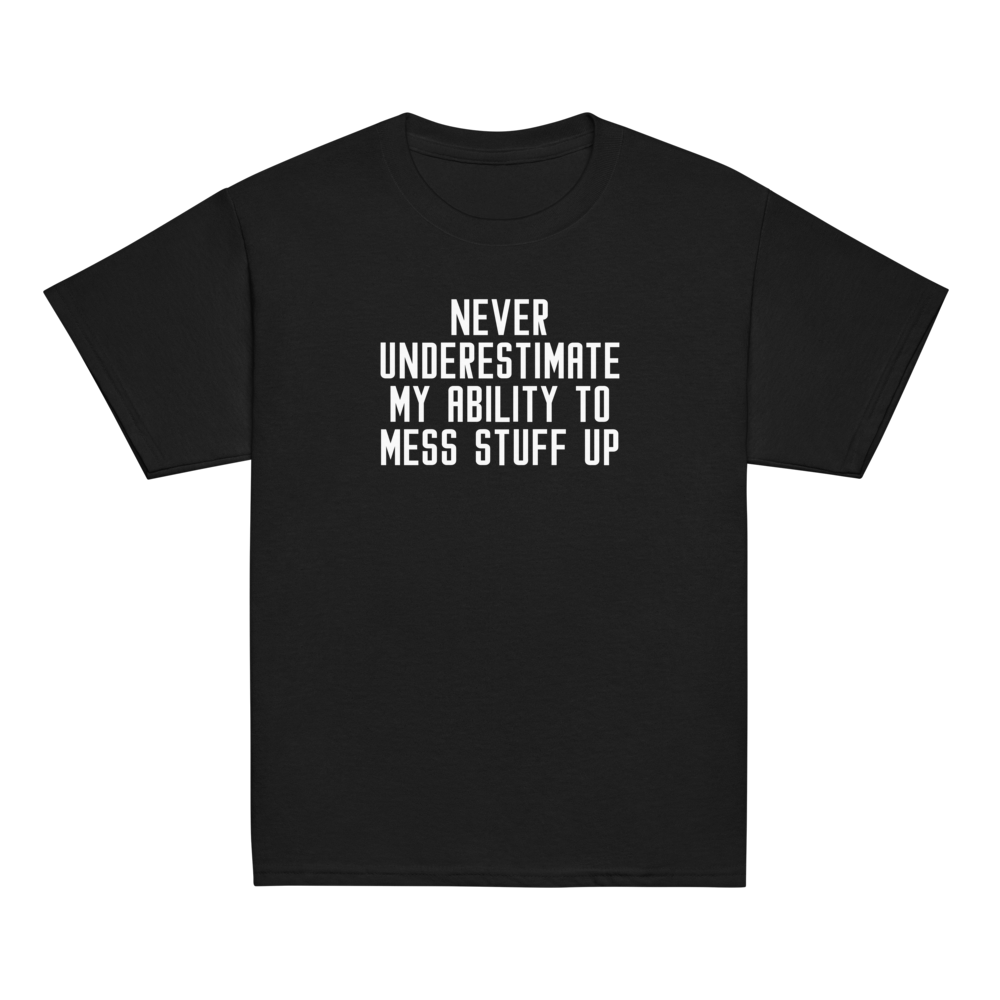 "Never Understimate My Ability To Mess Stuff Up" printed on a black youth classic tee laying on a flat surface