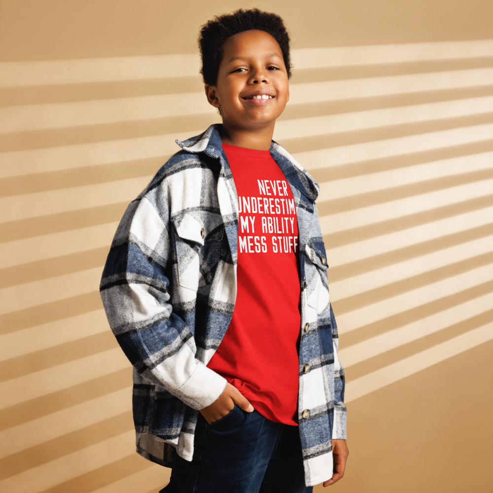 "Never Understimate My Ability To Mess Stuff Up" printed on a red youth classic tee worn by a male also wearing a jacket
