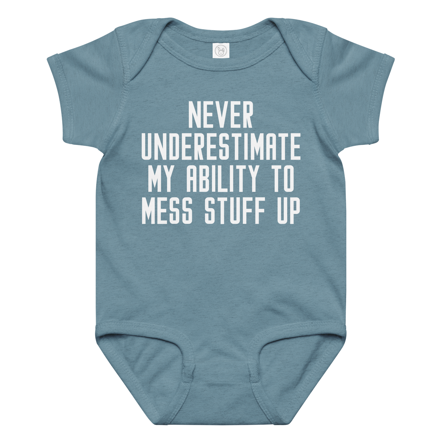 "Never Understimate My Ability To Mess Stuff Up" printed on a vintage indigo baby jersey bodysuit laying on a flat surface amongst other clothes