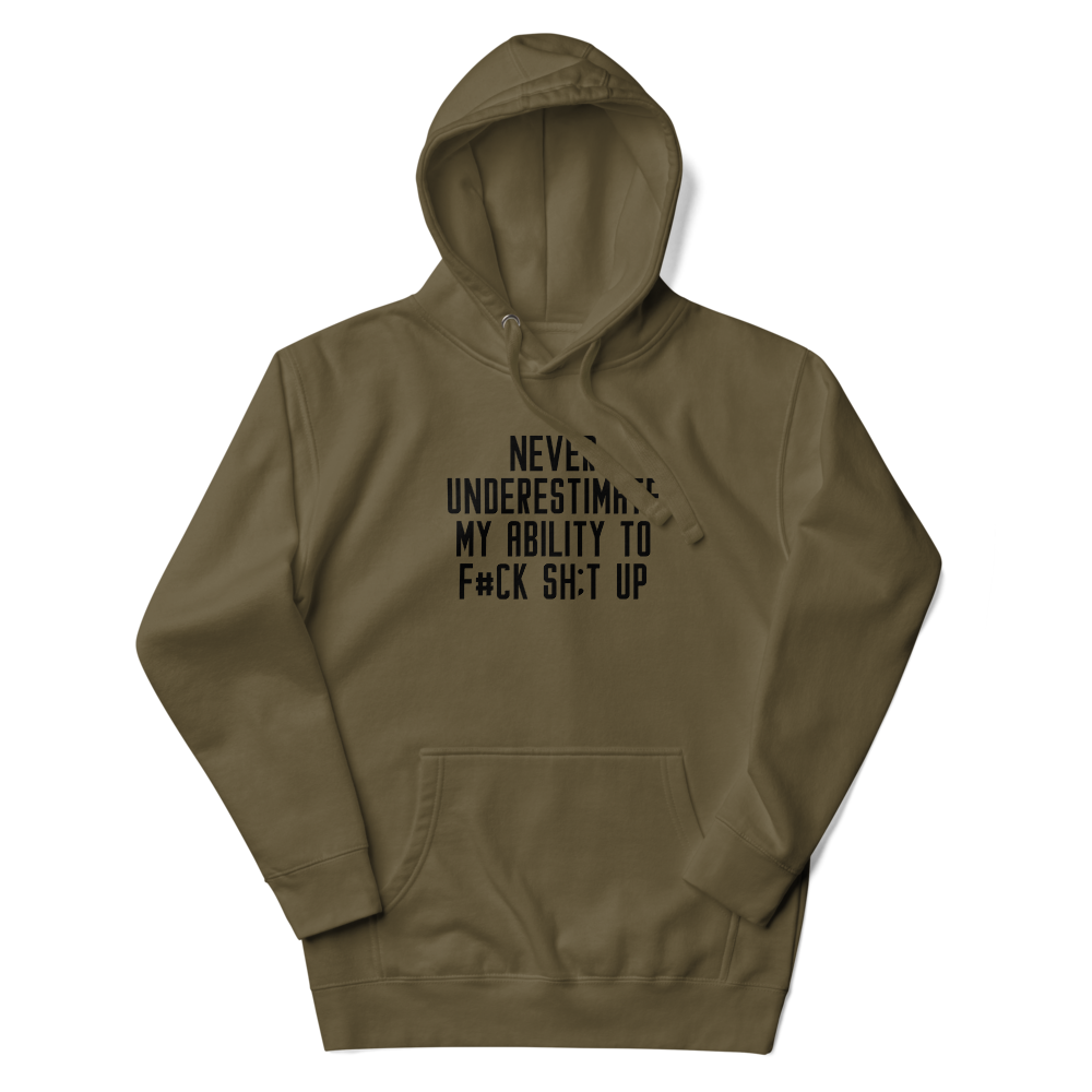 "Never Understimate My Ability To F#Ck Sh:t Up" printed on a military green unisex hoodie laying on a flat surface with the hood up