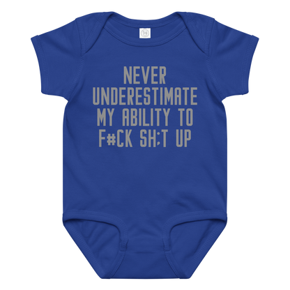 "Never Understimate My Ability To F#Ck Sh:t Up" printed on a royal baby jersey bodysuit laying on a flat surface amongst other clothes