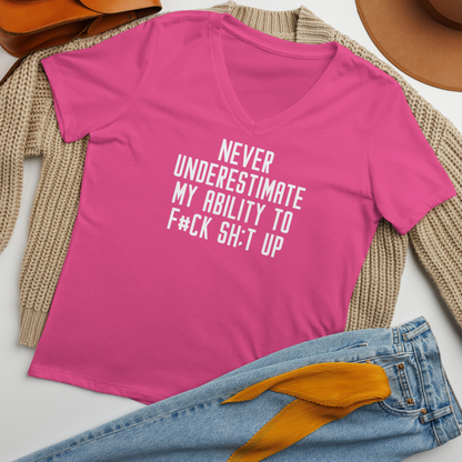 "Never Understimate My Ability To F#Ck Sh:t Up" printed on a berry women's relaxed v-neck t-shirt laying on a flat surface amongst other clothes