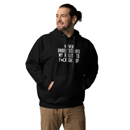 "Never Understimate My Ability To F#Ck Sh:t Up" printed on a black unisex hoodie worn by a male