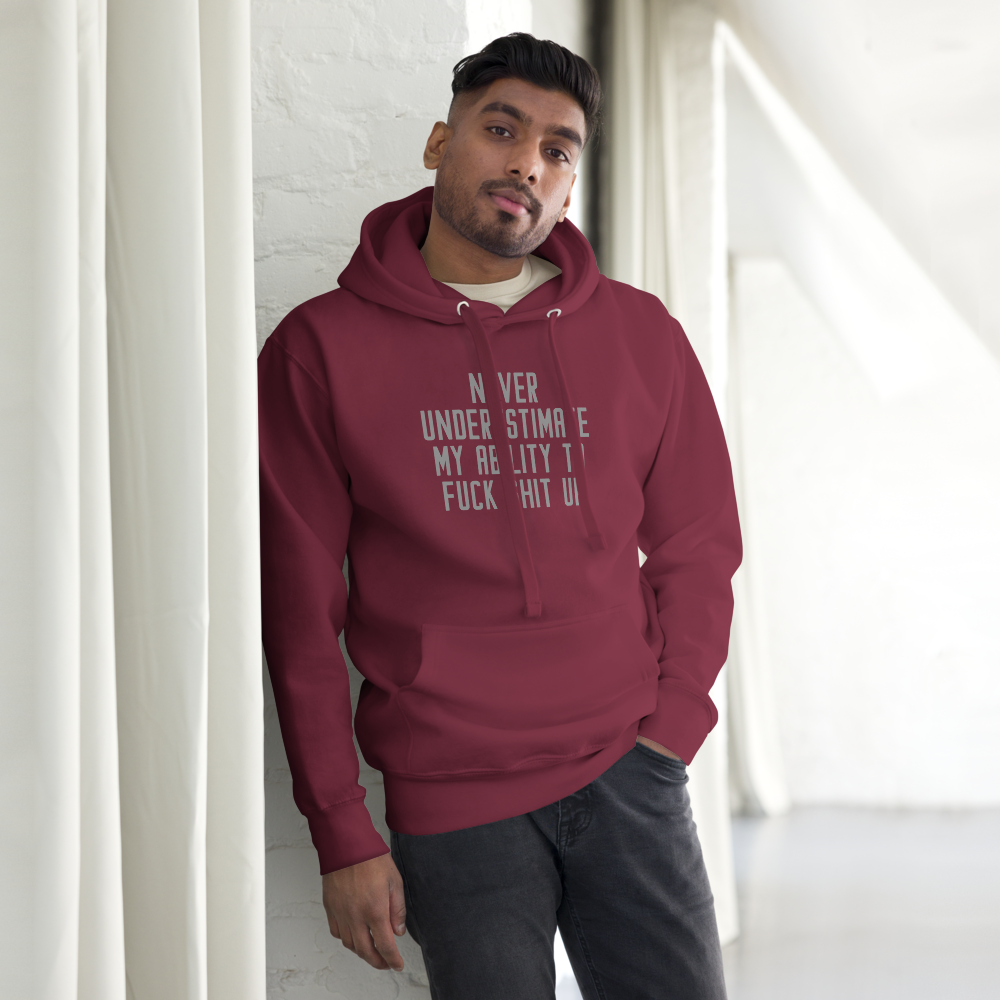 "Never Understimate My Ability To Fuck Shit Up" printed on a maroon unisex hoodie worn by a male