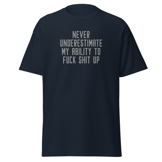 "Never Understimate My Ability To Fuck Shit Up" printed on a navy unisex classic tee laying on a flat surface