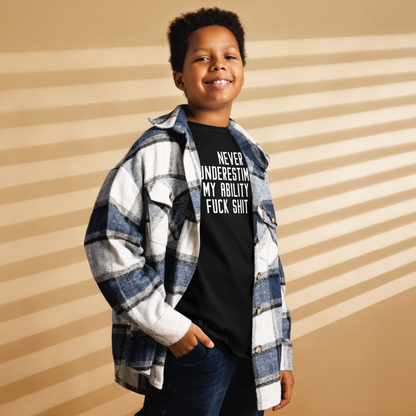 "Never Understimate My Ability To Fuck Shit Up" printed on a black youth classic tee worn by a male also wearing a jacket