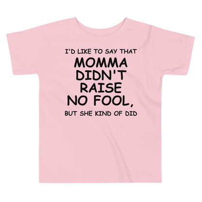 "I'd like to say that momma didn't raise no fool, but she kind of did" printed on a pink toddler short sleeve tee laying on a flat surface