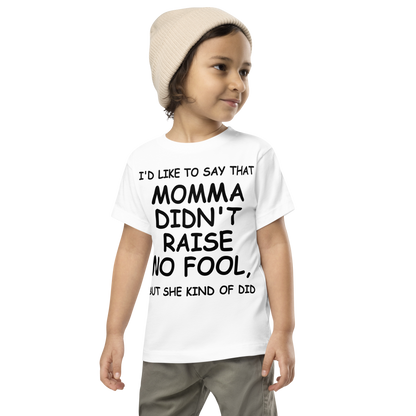 "I'd like to say that momma didn't raise no fool, but she kind of did" printed on a white toddler short sleeve tee worn by a male wearing a cap