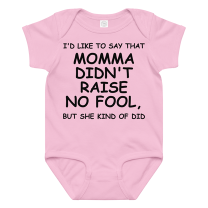"I'd like to say that momma didn't raise no fool, but she kind of did" printed on a pink baby jersey bodysuit laying on a flat surface amongst other clothes