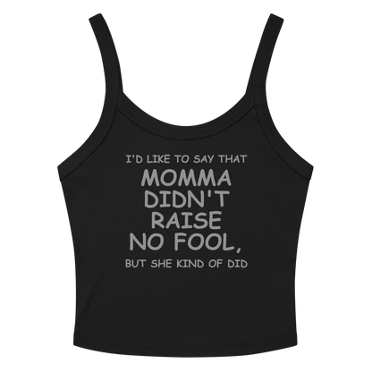 "I'd like to say that momma didn't raise no fool, but she kind of did" printed on a solid black blend women's micro-rib tanktop laying on a flat surface amongst sunglasses and shorts