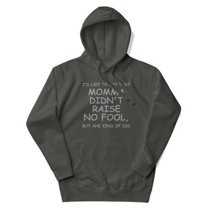 "I'd like to say that momma didn't raise no fool, but she kind of did" printed on a vintage black unisex hoodie laying on a flat surface with the hood up