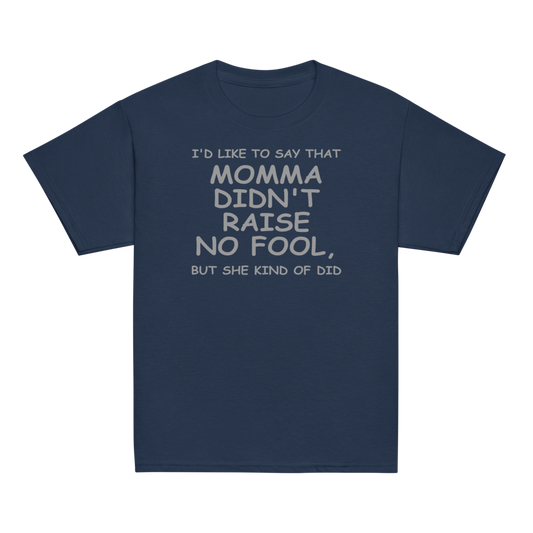 "I'd like to say that momma didn't raise no fool, but she kind of did" printed on a navy youth classic tee laying on a flat surface