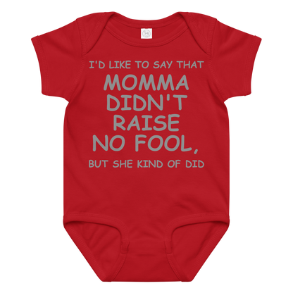 "I'd like to say that momma didn't raise no fool, but she kind of did" printed on a red baby jersey bodysuit laying on a flat surface amongst other clothes