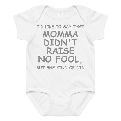 "I'd like to say that momma didn't raise no fool, but she kind of did" printed on a white baby jersey bodysuit laying on a flat surface amongst other clothes