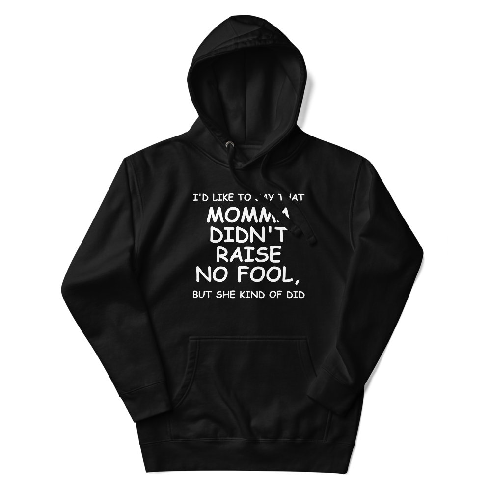 "I'd like to say that momma didn't raise no fool, but she kind of did" printed on a black unisex hoodie laying on a flat surface with the hood up