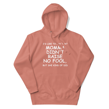"I'd like to say that momma didn't raise no fool, but she kind of did" printed on a dusty rose unisex hoodie laying on a flat surface with the hood up