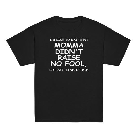 "I'd like to say that momma didn't raise no fool, but she kind of did" printed on a black youth classic tee laying on a flat surface