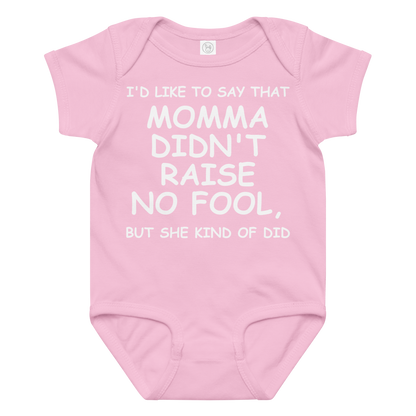 "I'd like to say that momma didn't raise no fool, but she kind of did" printed on a pink baby jersey bodysuit laying on a flat surface amongst other clothes
