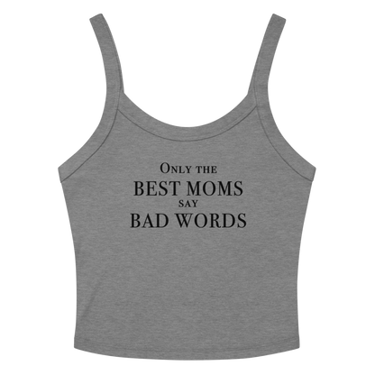 "Only the best moms say bad words" printed on a athletic heather women's micro-rib tanktop laying on a flat surface amongst sunglasses and shorts