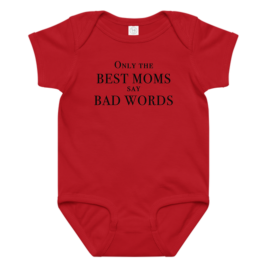 "Only the best moms say bad words" printed on a red baby jersey bodysuit laying on a flat surface amongst other clothes