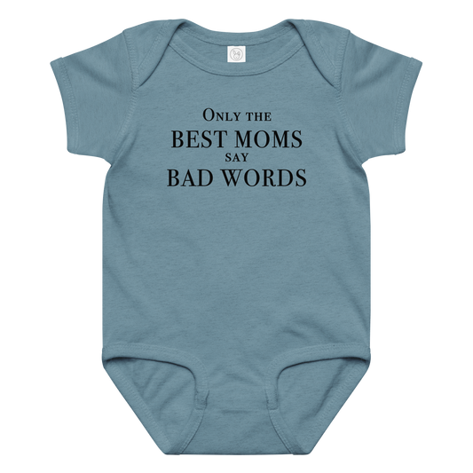 "Only the best moms say bad words" printed on a vintage indigo baby jersey bodysuit laying on a flat surface amongst other clothes