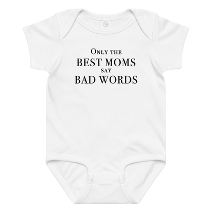 "Only the best moms say bad words" printed on a white baby jersey bodysuit laying on a flat surface amongst other clothes