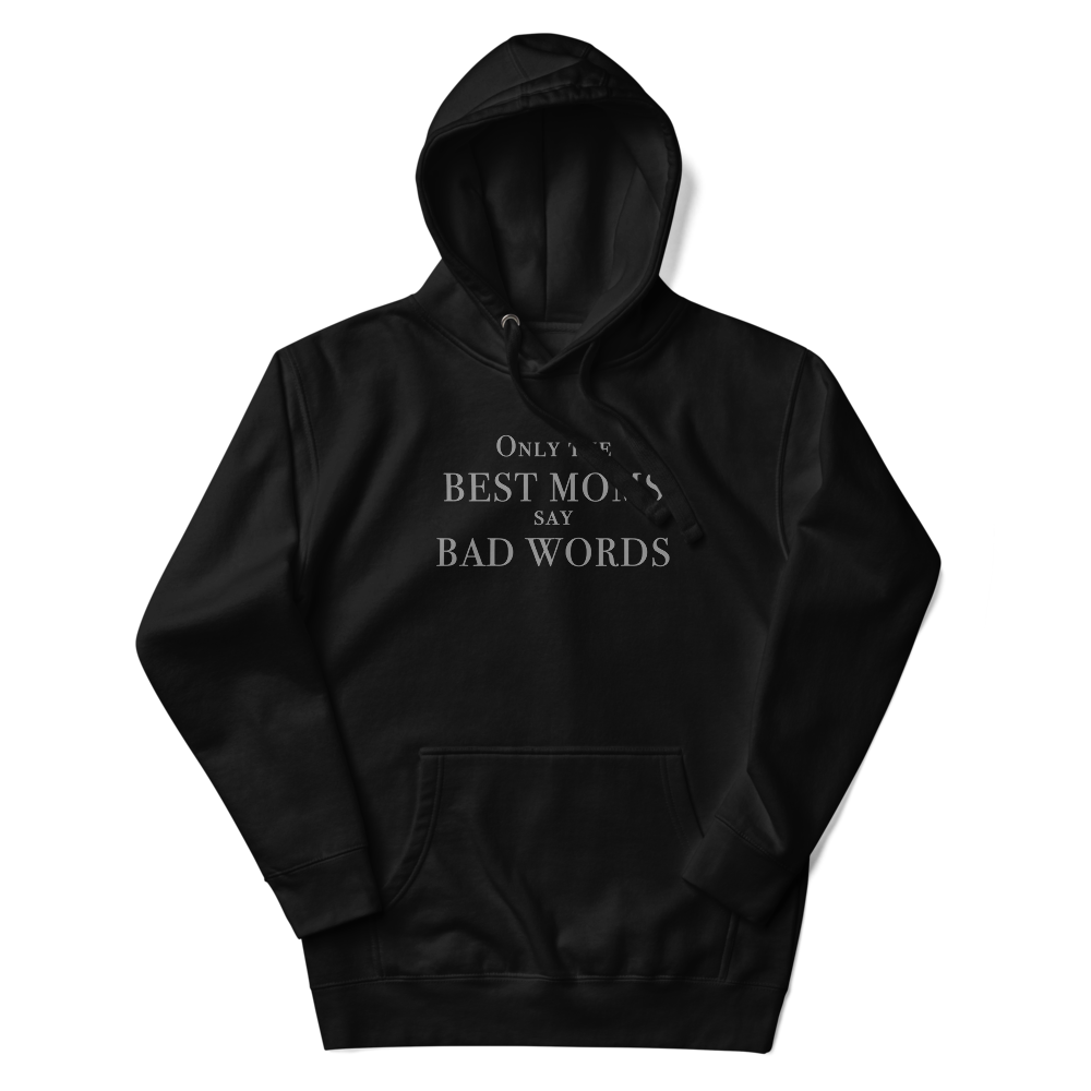 "Only the best moms say bad words" printed on a black unisex hoodie laying on a flat surface with the hood up