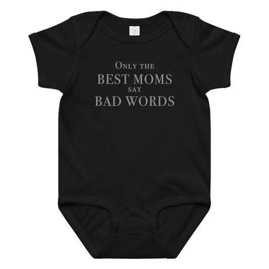 "Only the best moms say bad words" printed on a black baby jersey bodysuit laying on a flat surface amongst other clothes