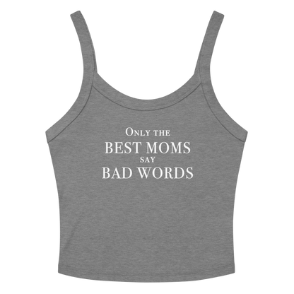 "Only the best moms say bad words" printed on a athletic heather women's micro-rib tanktop laying on a flat surface amongst sunglasses and shorts