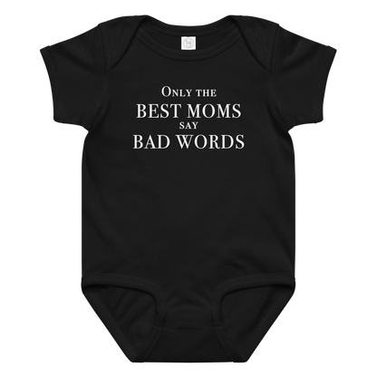 "Only the best moms say bad words" printed on a black baby jersey bodysuit laying on a flat surface amongst other clothes
