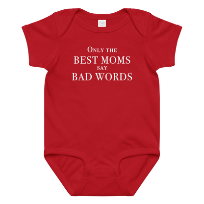 "Only the best moms say bad words" printed on a red baby jersey bodysuit laying on a flat surface amongst other clothes