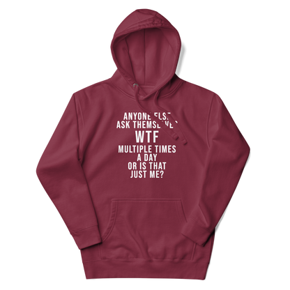 "Anyone else ask themselves WTF multiple times a day or is that just me?" printed on a maroon unisex hoodie laying on a flat surface with the hood up