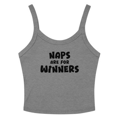 "Naps Are For Winners" printed on a athletic heather women's micro-rib tanktop laying on a flat surface amongst sunglasses and shorts