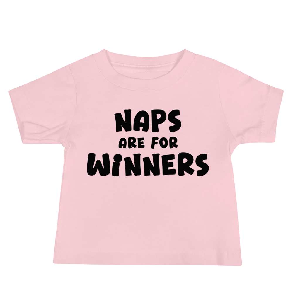 "Naps Are For Winners" printed on a pink baby jersey short sleeve tee laying on a flat surface