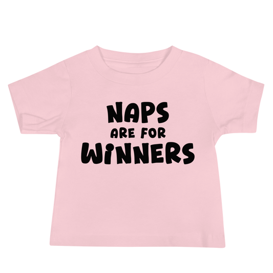"Naps Are For Winners" printed on a pink baby jersey short sleeve tee laying on a flat surface