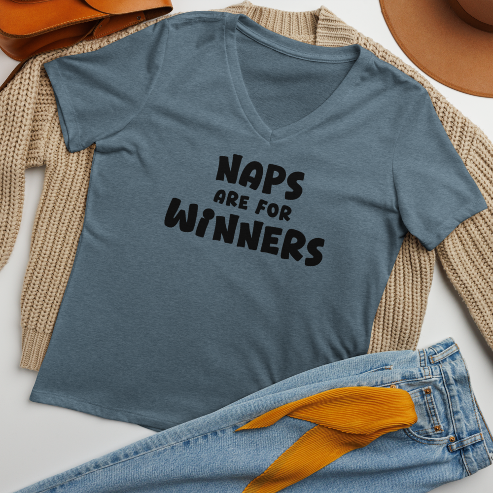 "Naps Are For Winners" printed on a heather slate women's relaxed v-neck t-shirt laying on a flat surface amongst other clothes