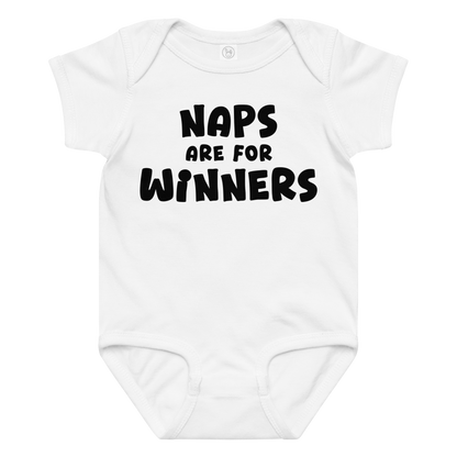 "Naps Are For Winners" printed on a white baby jersey bodysuit laying on a flat surface amongst other clothes