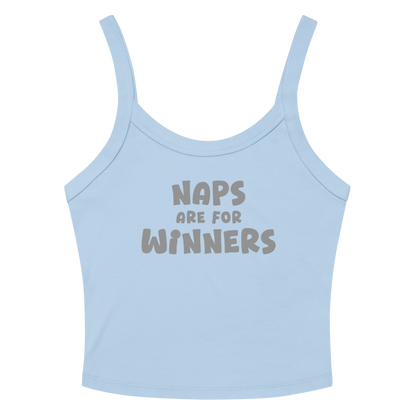 "Naps Are For Winners" printed on a solid baby blue blend women's micro-rib tanktop laying on a flat surface amongst sunglasses and shorts