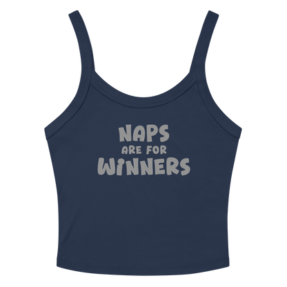 "Naps Are For Winners" printed on a solid navy blend women's micro-rib tanktop laying on a flat surface amongst sunglasses and shorts