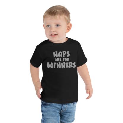 "Naps Are For Winners" printed on a black toddler short sleeve tee worn by a male