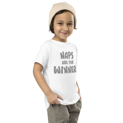 "Naps Are For Winners" printed on a white toddler short sleeve tee worn by a male who is also wearing a knit cap