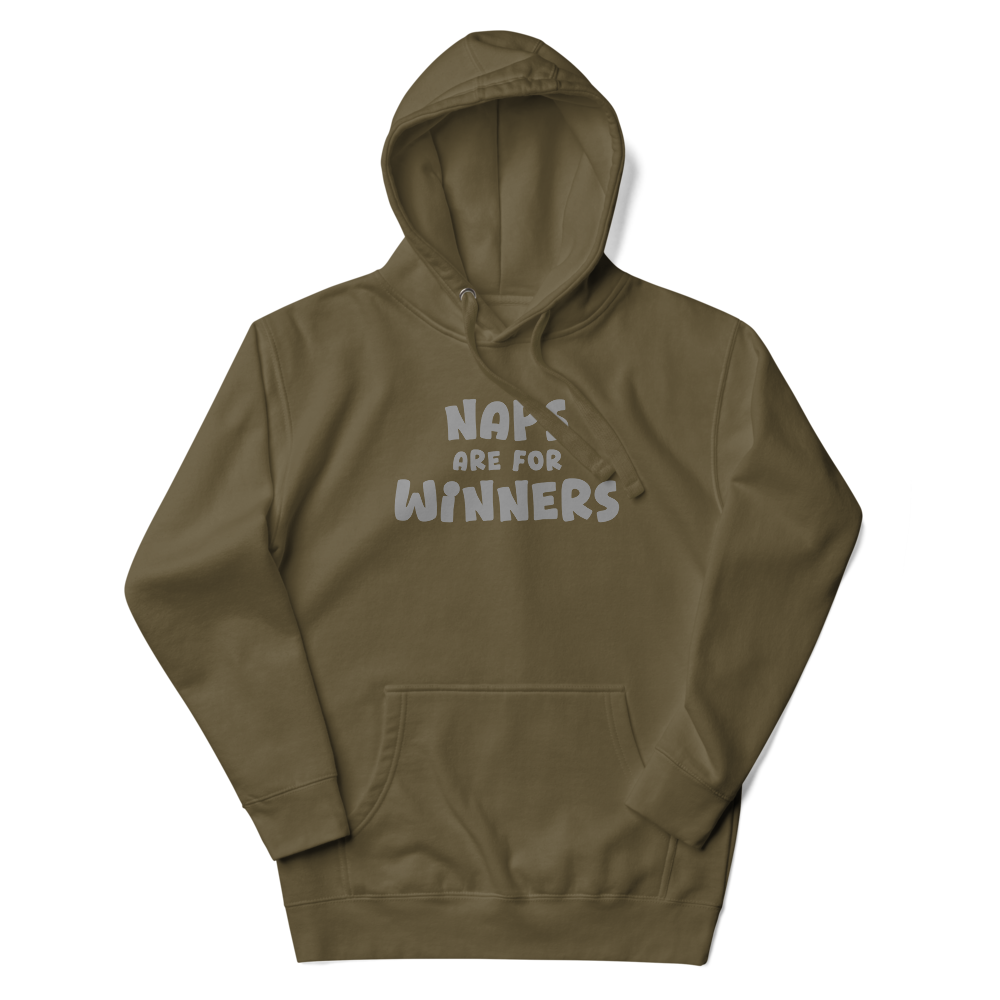 "Naps Are For Winners" printed on a military green unisex hoodie laying on a flat surface with the hood up