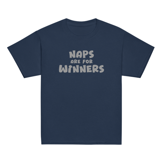 "Naps Are For Winners" printed on a navy youth classic tee laying on a flat surface
