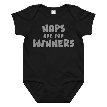 "Naps Are For Winners" printed on a black baby jersey bodysuit laying on a flat surface amongst other clothes