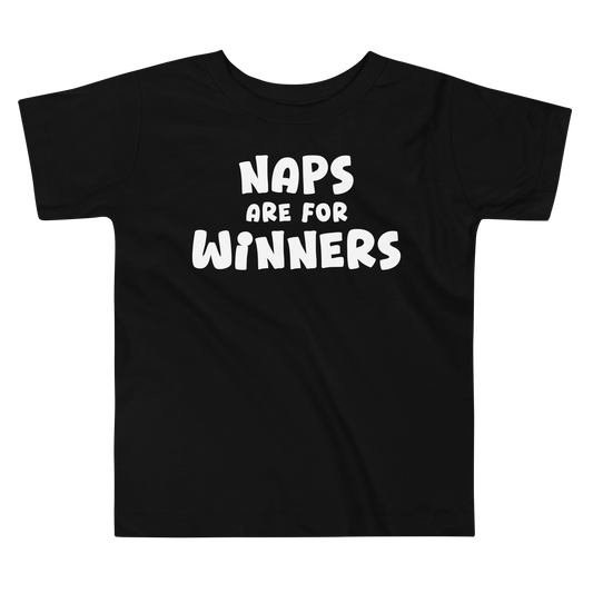 "Naps Are For Winners" printed on a black toddler short sleeve tee laying on a flat surface