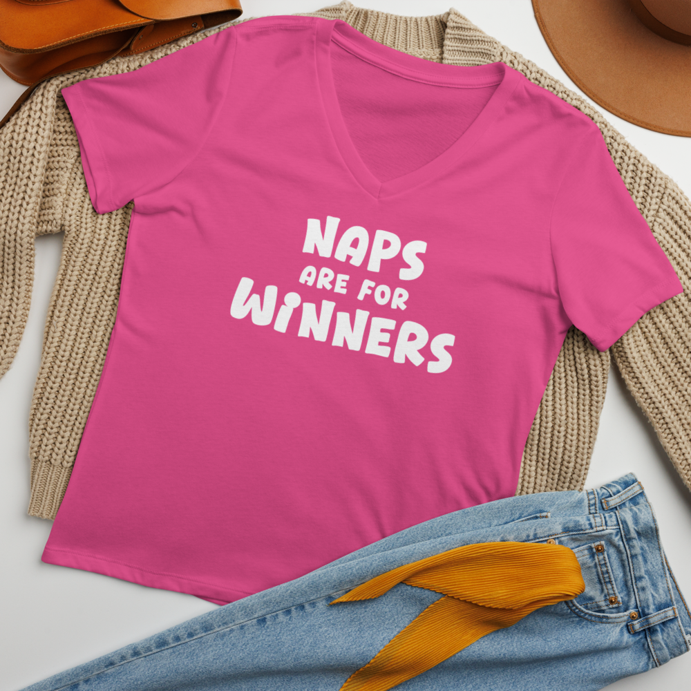 "Naps Are For Winners" printed on a berry women's relaxed v-neck t-shirt laying on a flat surface amongst other clothes